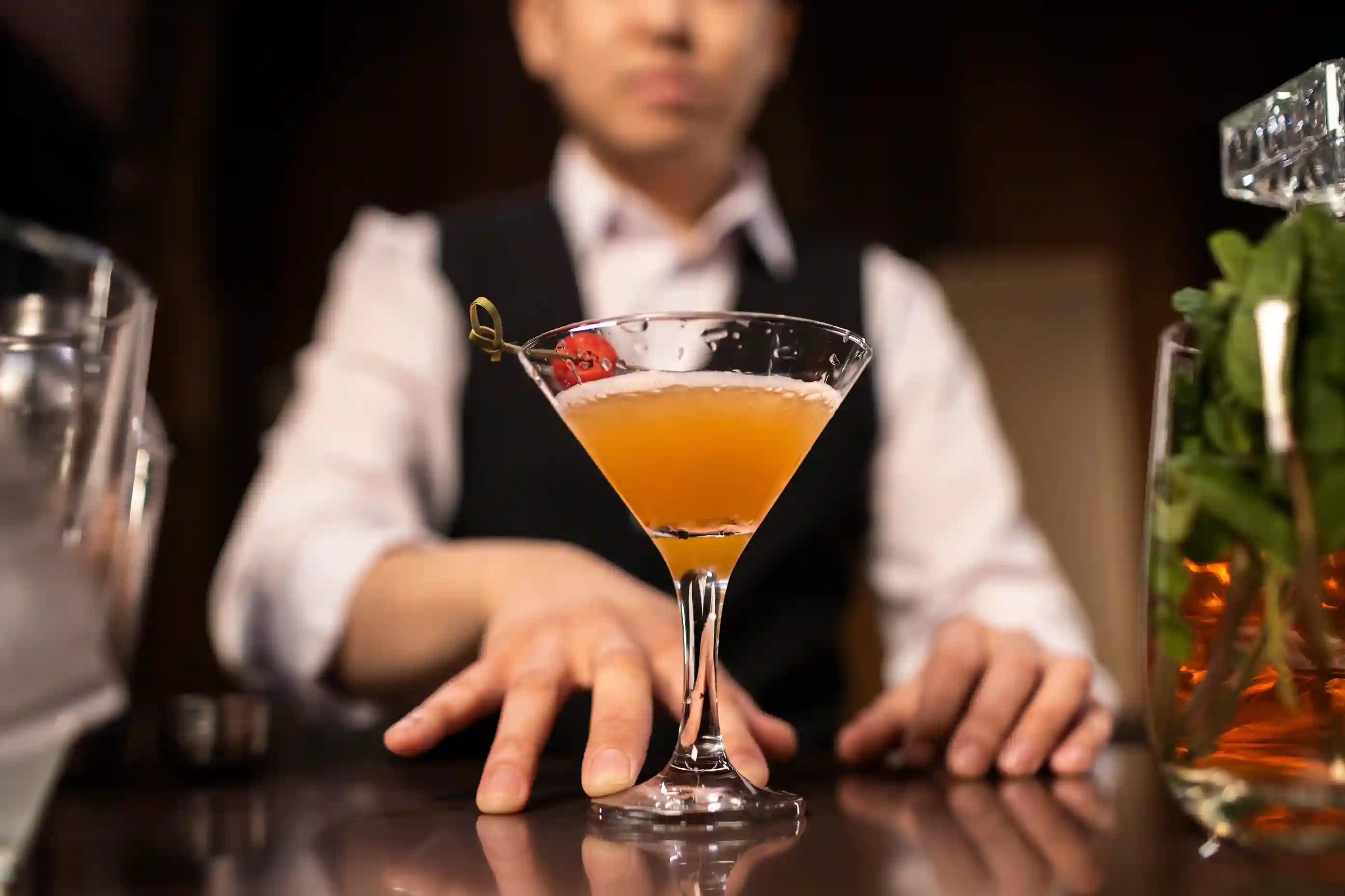 Bartender presenting a tray of colorful, garnished cocktails from the AW Mobile Bar